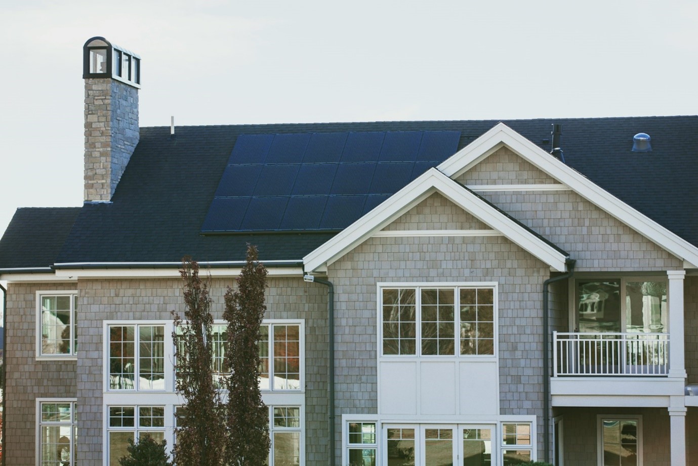 Des panneaux solaires photovoltaïques disposés en portrait sur le toit d’une maison.