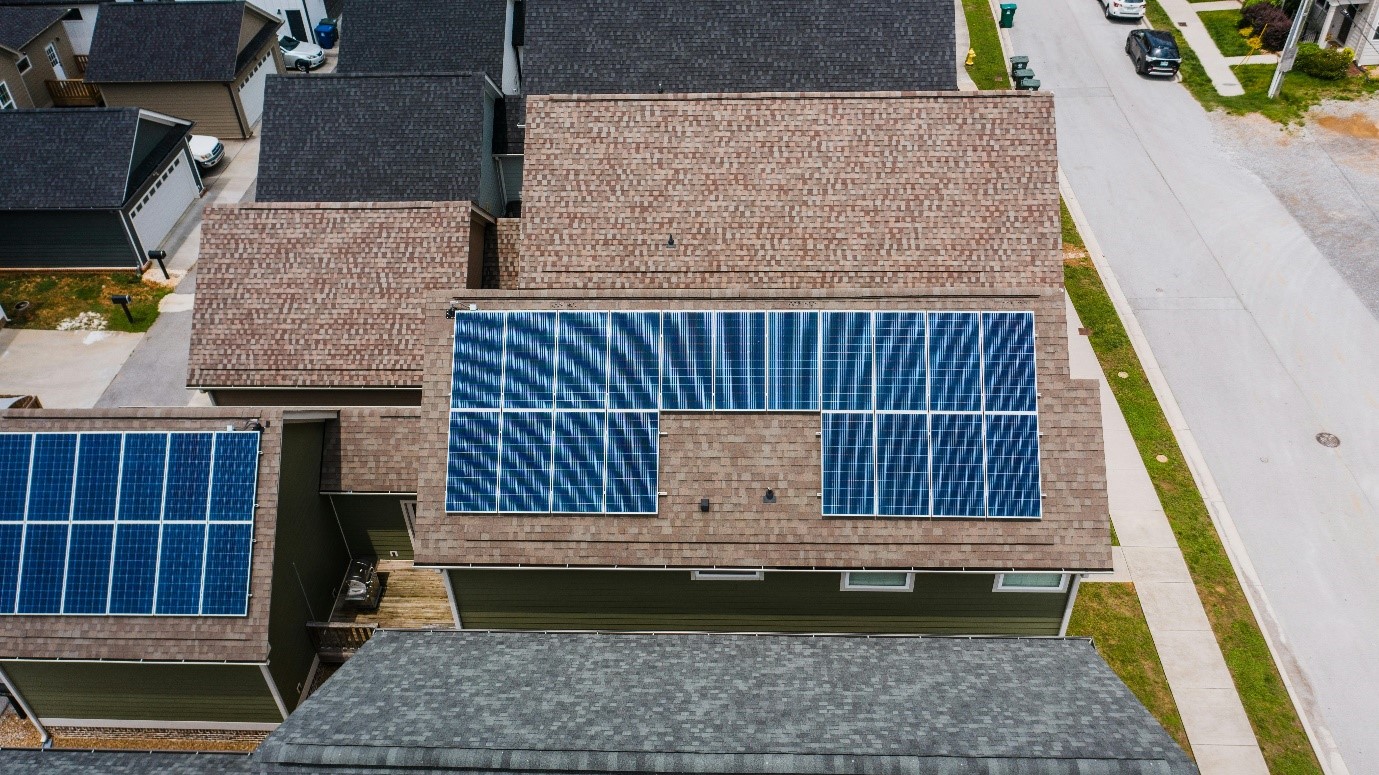 Alt=»Nettoyage panneau solaire. Vue aérienne de panneaux solaires installés en toiture»