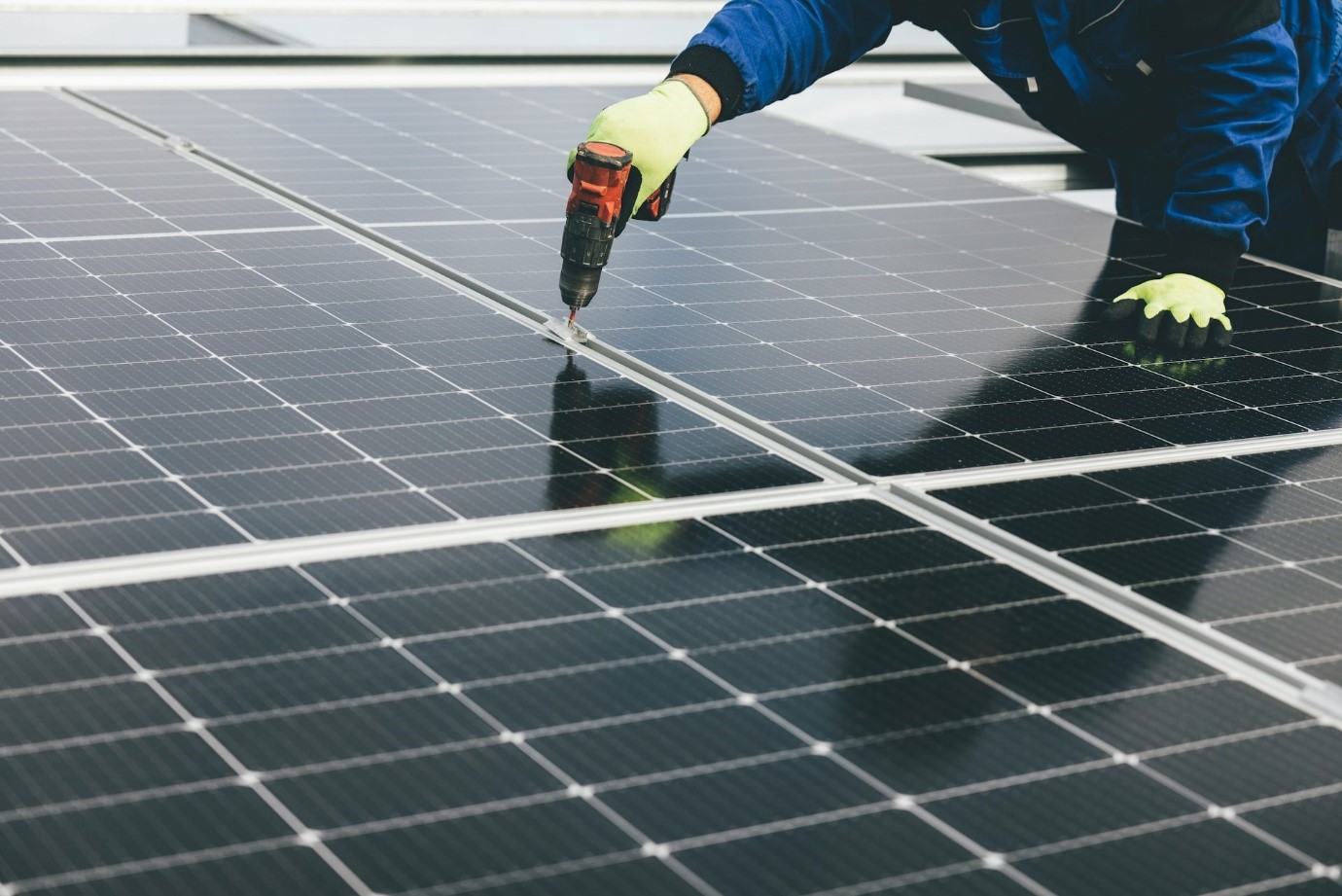 Alt=»Qui peut installer des panneaux solaires ? Artisan en train d'installer des panneaux photovoltaïques.»